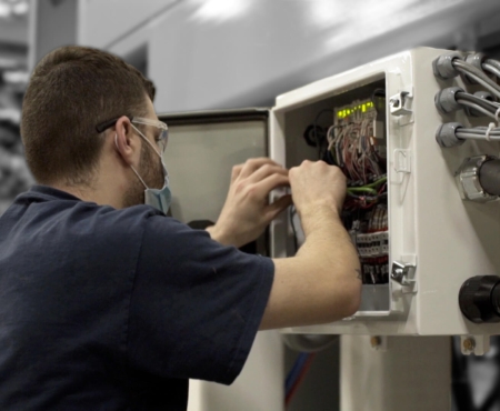 electrician testing a machine as part of solution design and parts and maintenance