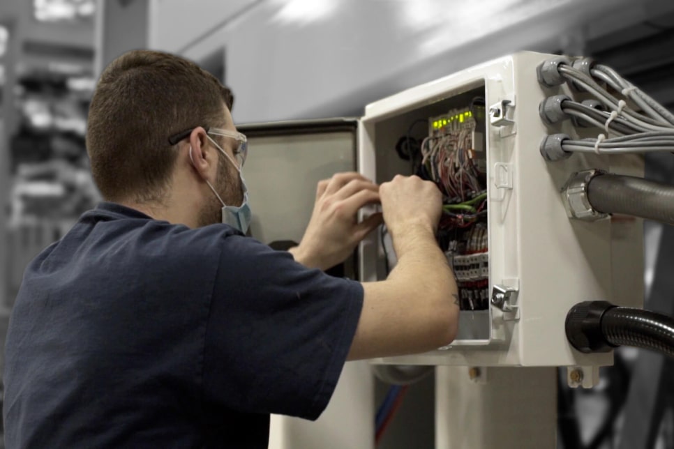 electrician testing a machine as part of solution design and parts and maintenance