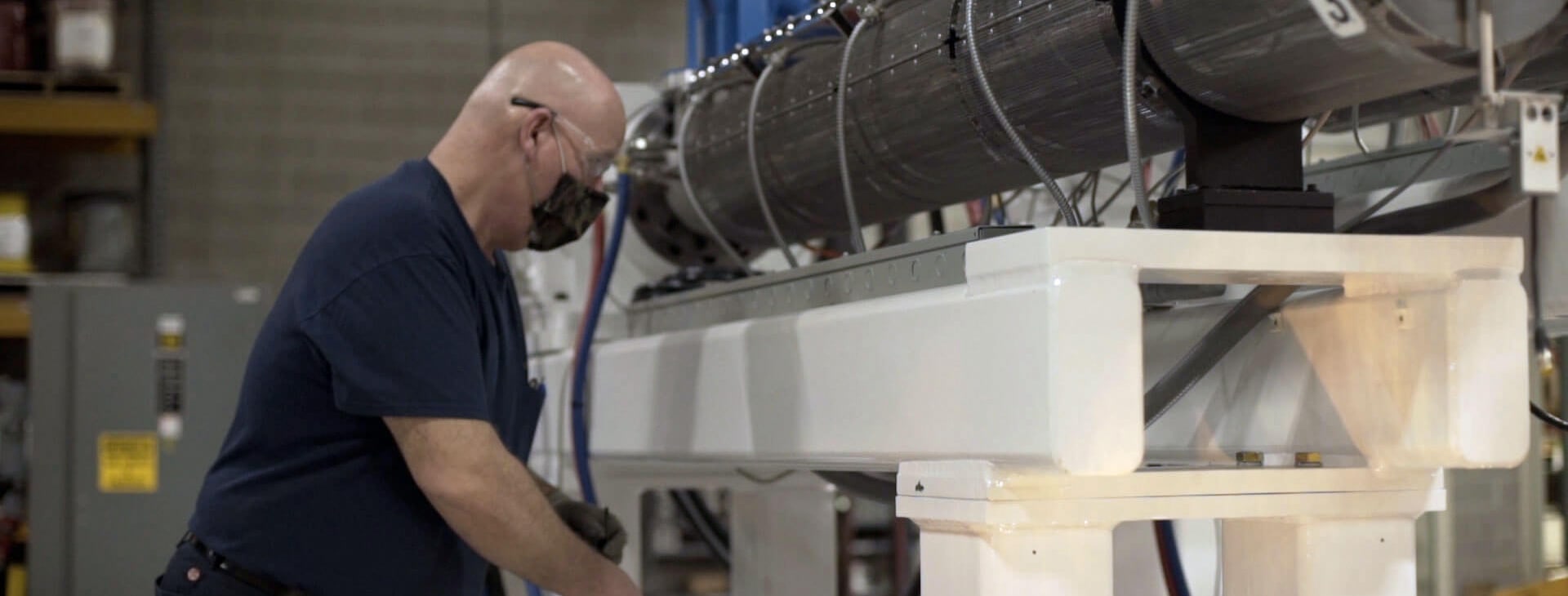 lifecycle management includes maintenance like this Graham employee working on an extruder