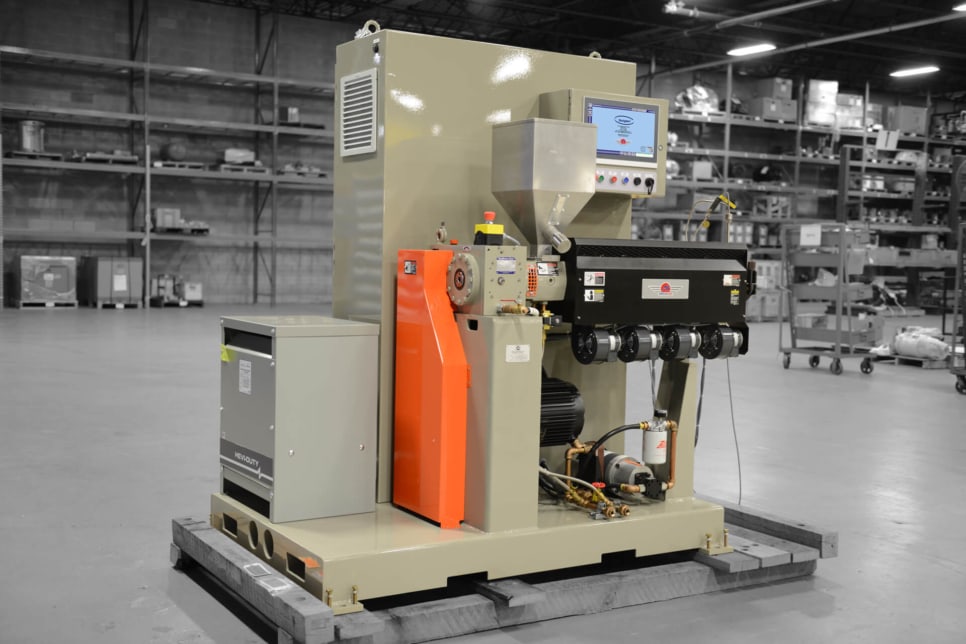 Ultra extruder pictured in grey-brown in a factory setting.
