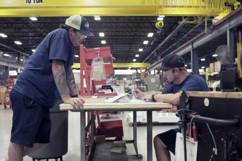 Two graham engineering people working at a table on the factory floor