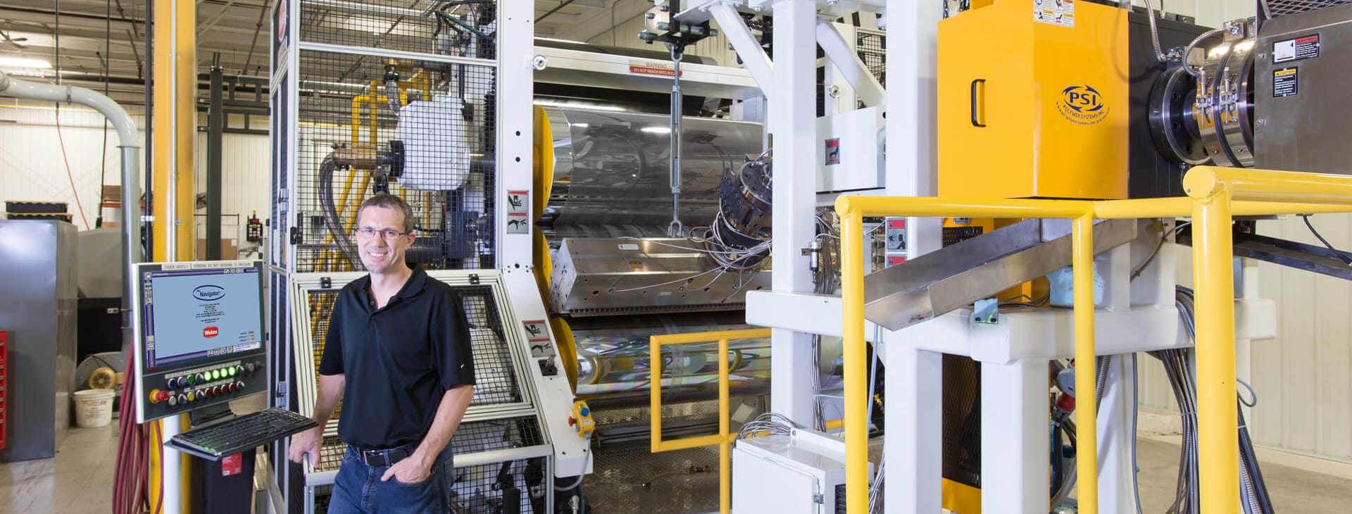 man standing in front of his Graham Extrusion equipment for parts and maintenance services photo
