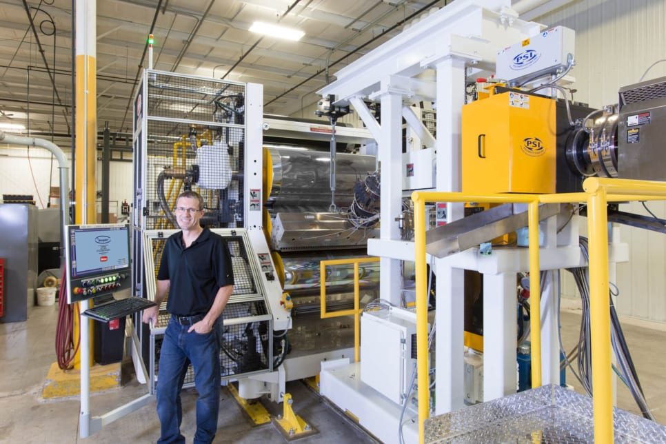 man standing in front of his Graham Extrusion equipment for parts and maintenance services photo